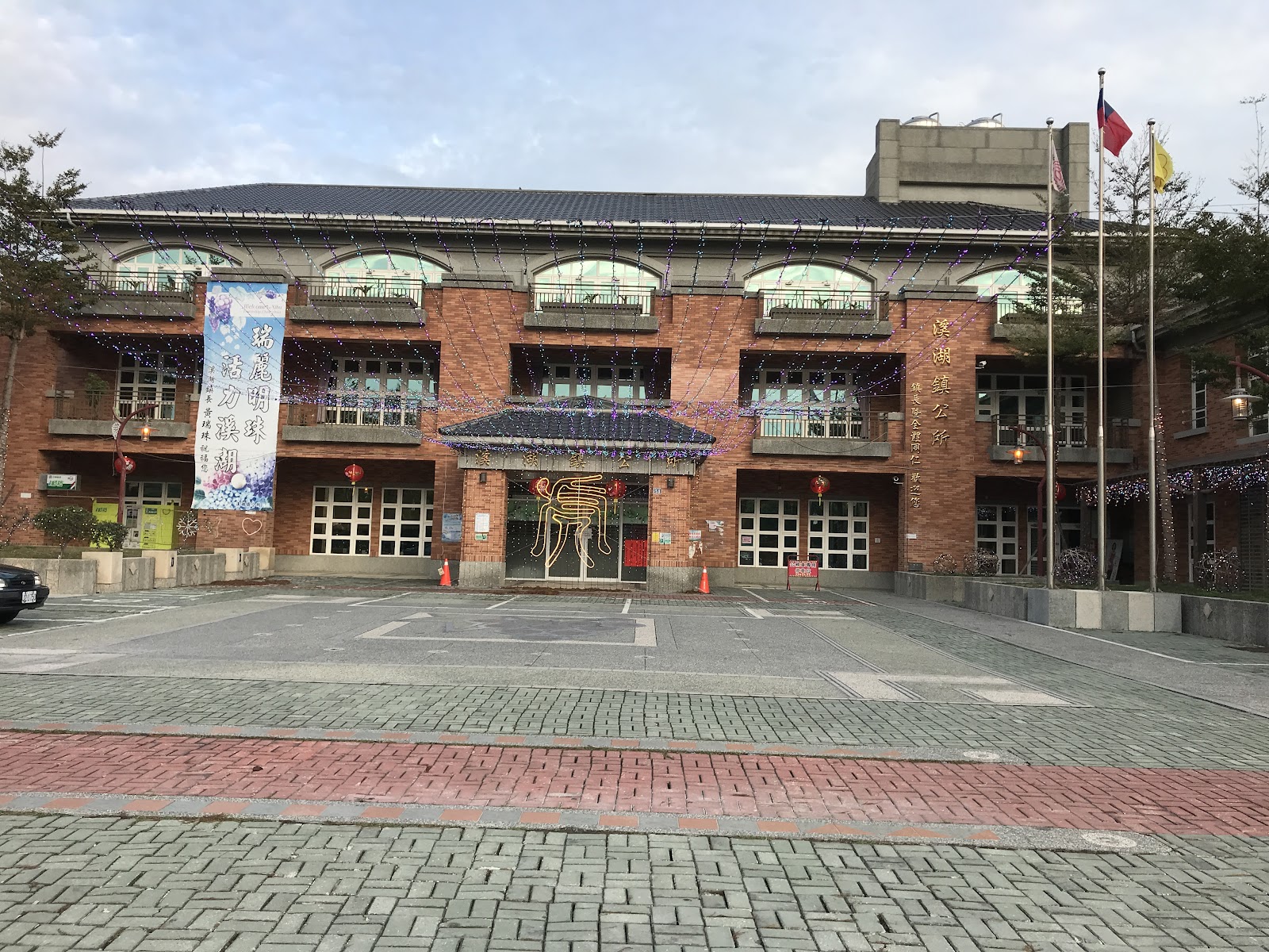 彰化溪湖鎮公所紅磚建築外觀，國旗與燈飾妝點門口廣場