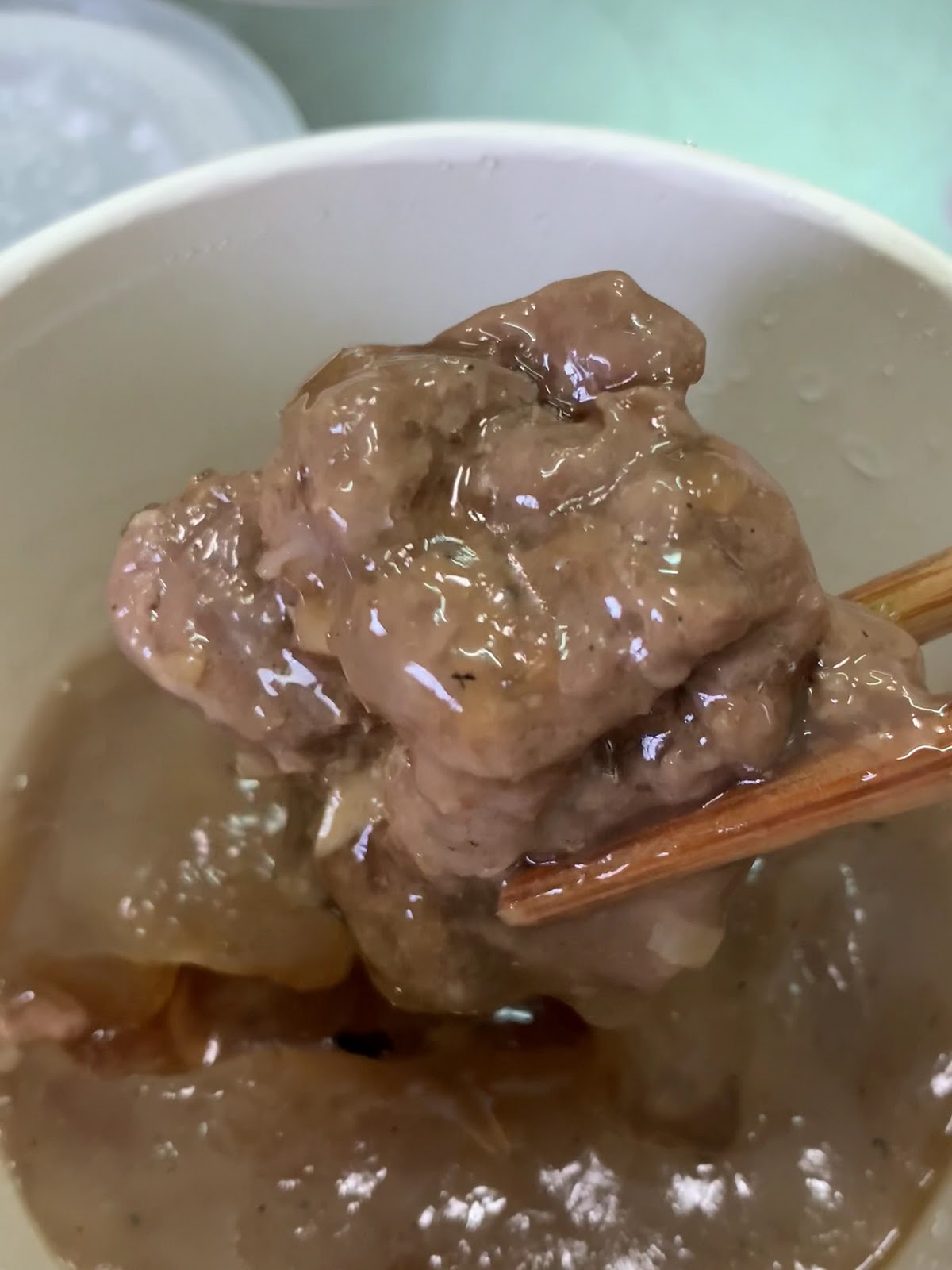 溪湖古早味肉圓川招牌肉圓特寫，筷子夾起沾滿醬汁