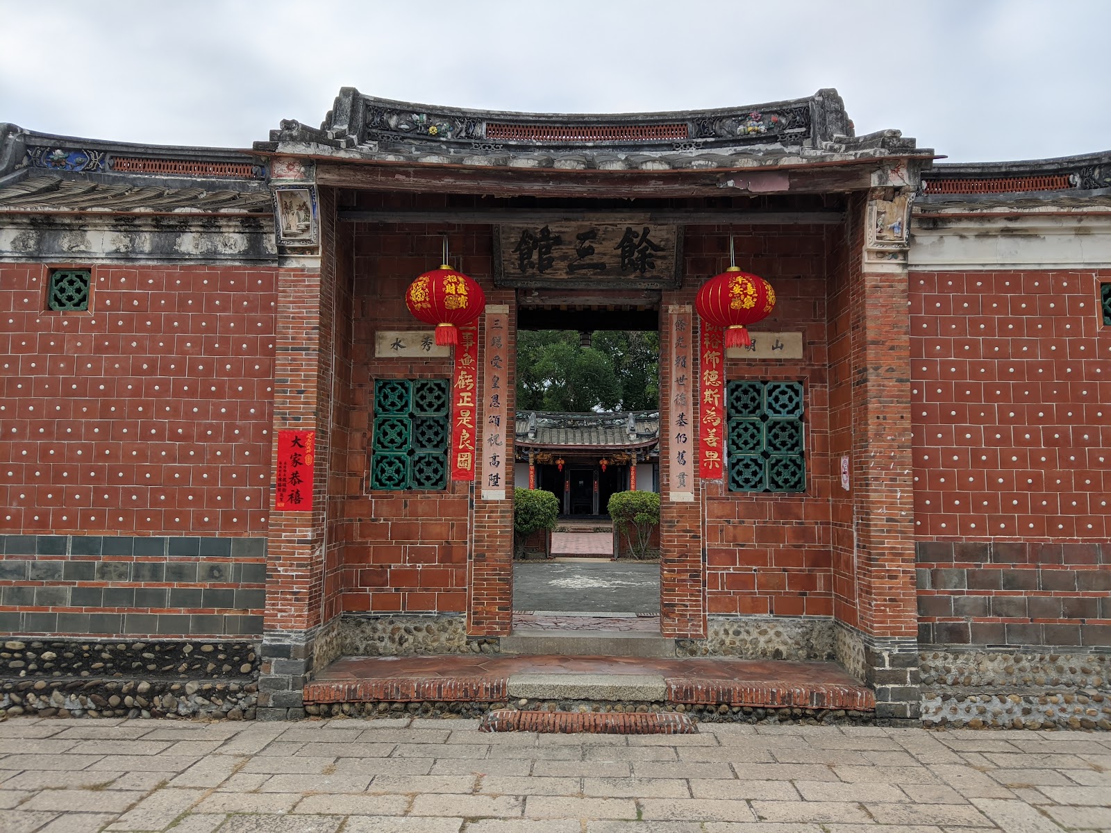 餘三館院門敞開,可見內埕與正廳屋頂一角