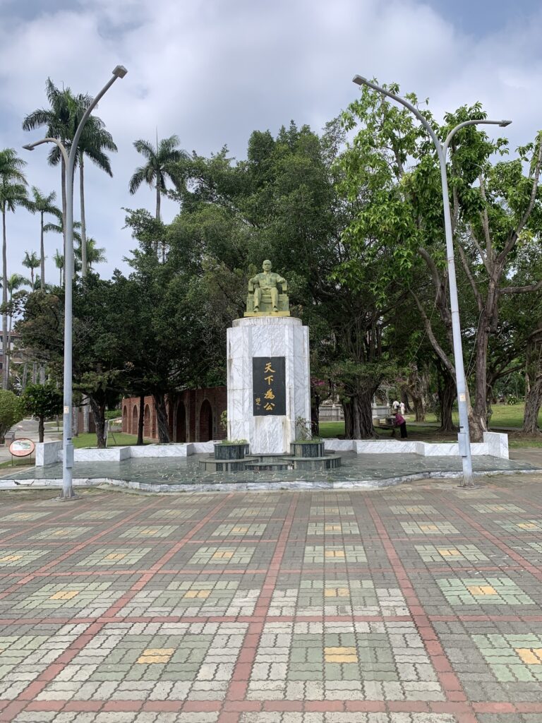 嘉義公園－園內國父孫中山銅像與「天下為公」紀念碑，周圍是高聳的大王椰子與噴水池