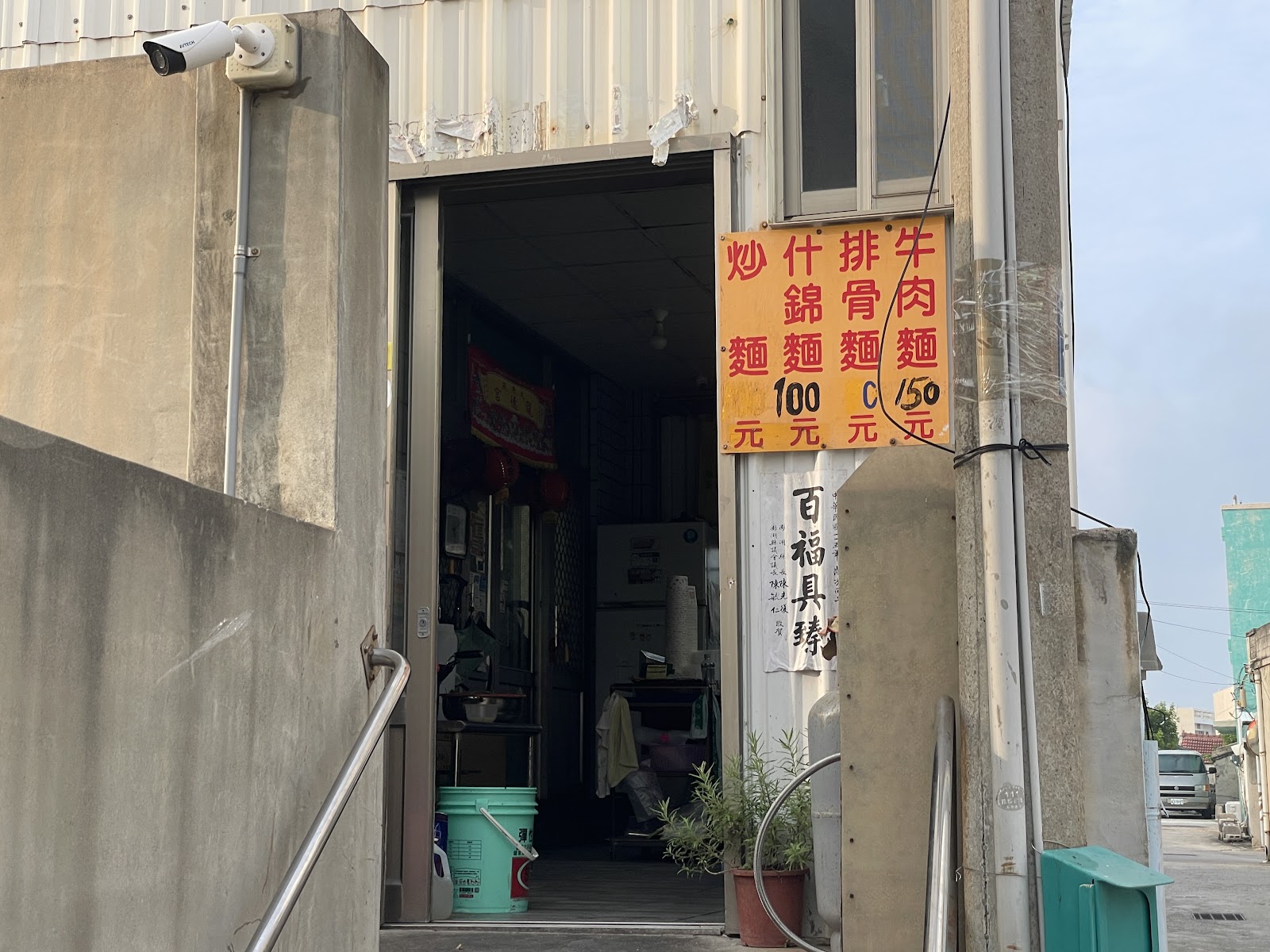 赤崁牛肉麵鐵皮店面，橘底紅字菜單招牌寫著牛肉麵、排骨麵等選項