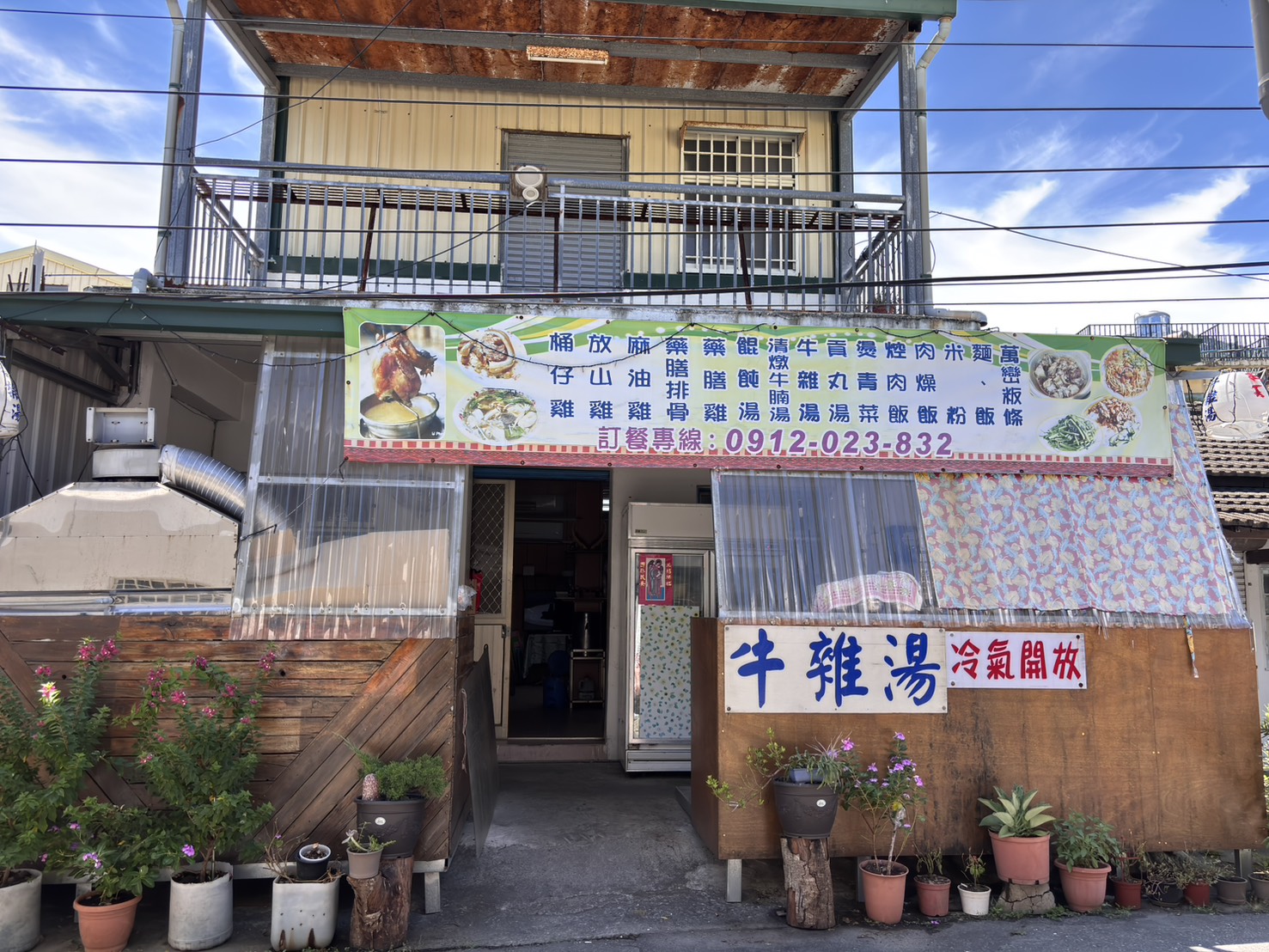 春雨小吃店面外觀 春雨小吃店面外觀,黃色鐵皮樓房掛著菜單布條