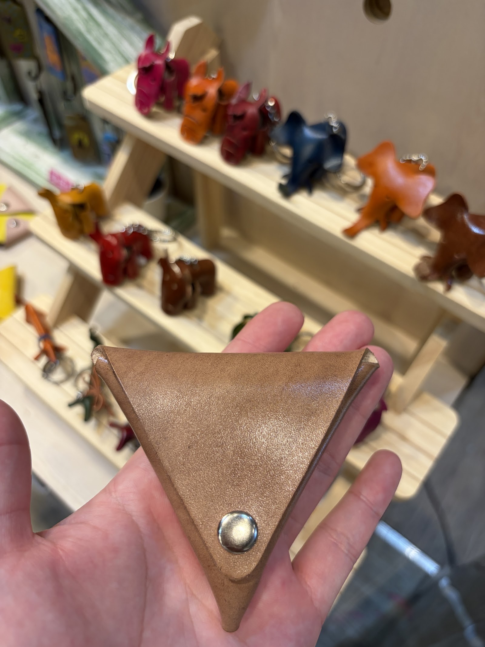 木架展示多款彩色皮革手作包與鑰匙圈成品