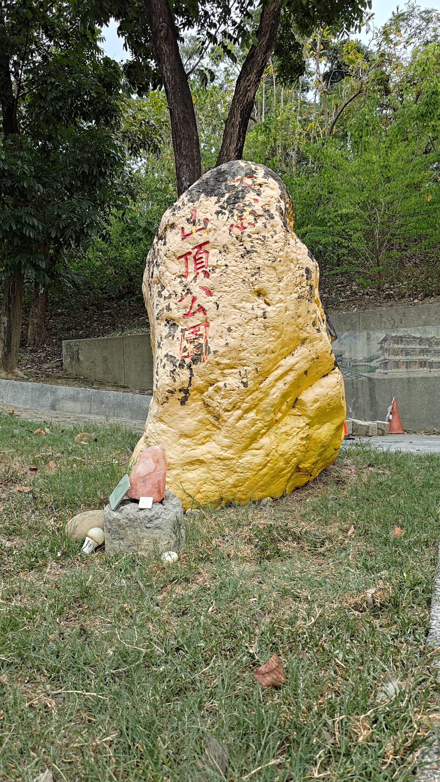 山頂公園入口石碑，黃色大石頭刻有山頂公園字樣，周圍樹木環繞