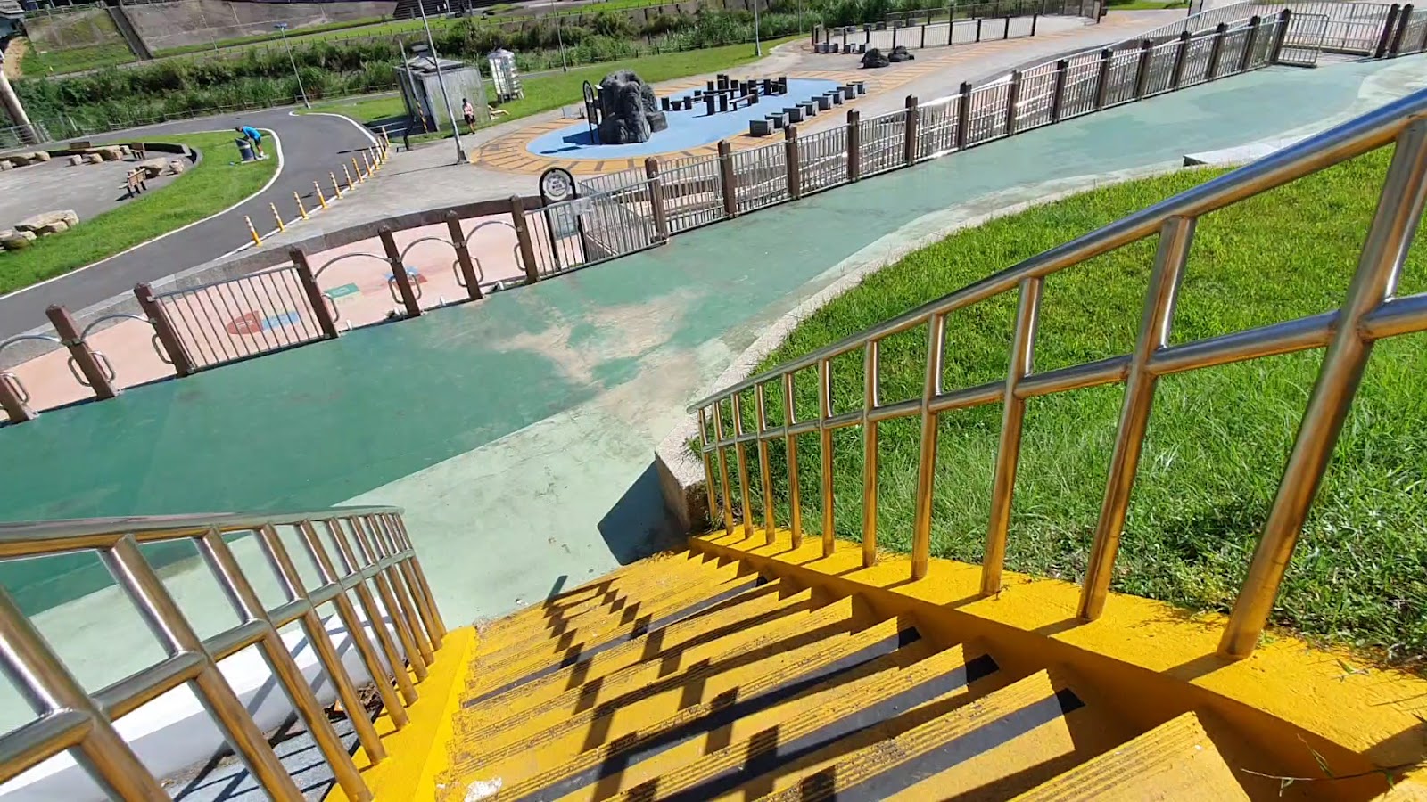 道南河濱公園樓梯俯瞰綠色透水鋪面廣場與兒童攀爬石景遊具