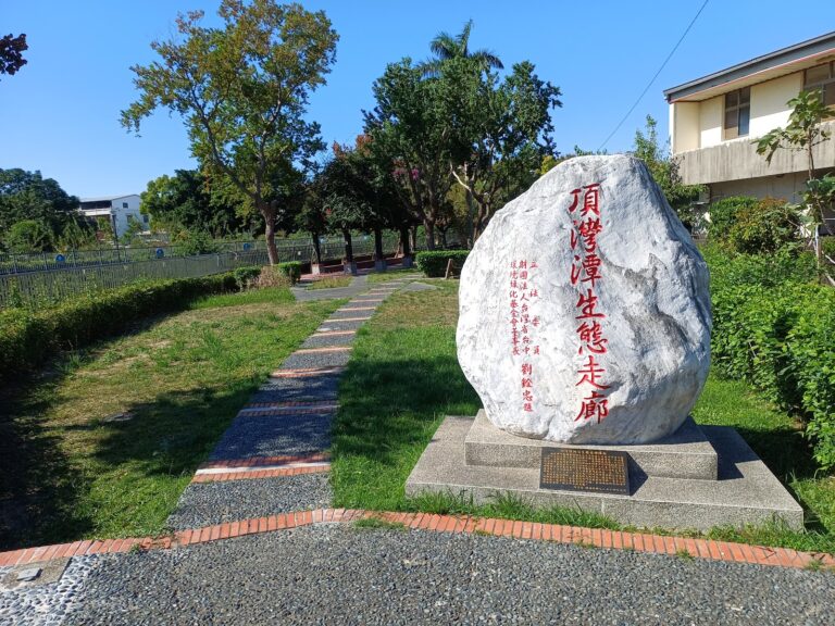頂灣潭生態走廊入口立石標示，沿圳溝綠蔭步道而行