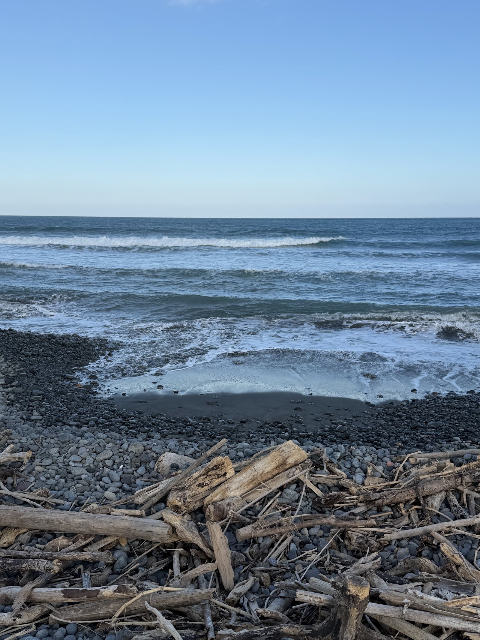 鉛橋海灘漂流木與礫石灘,浪花拍打岸邊