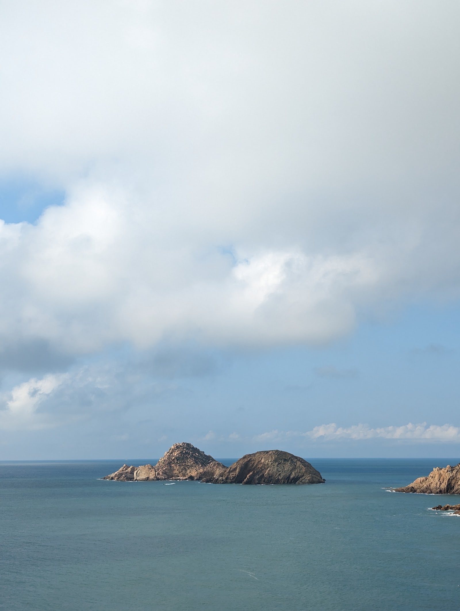 陰雲天空下林坳嶼雙峰岩島直幅構圖