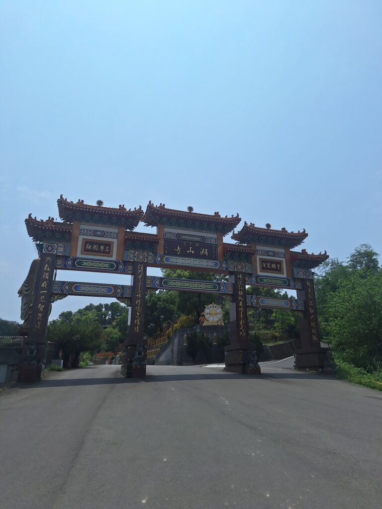 湖山岩牌樓入口,紅色廟宇式山門矗立道路盡頭