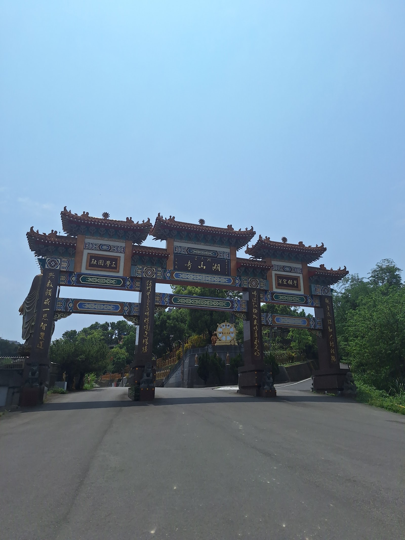 湖山岩牌樓入口,紅色廟宇式山門矗立道路盡頭