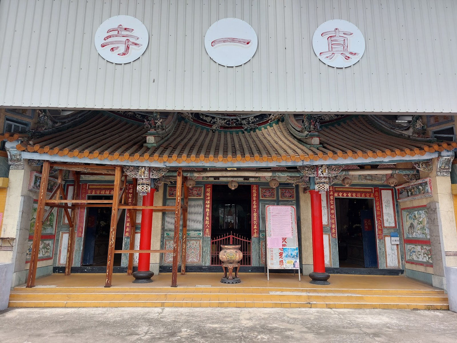 縣定古蹟斗六真一寺廟埕正面，紅柱與施工鷹架並存