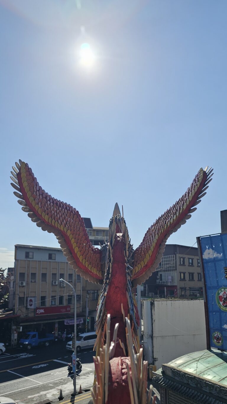 礁溪協天廟屋頂鳳凰剪黏特寫，背景礁溪街景
