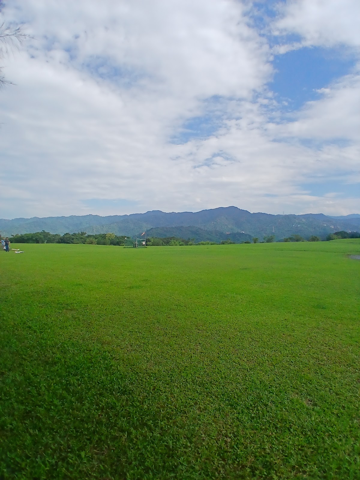福德坑環保復育公園偌大綠草皮遙控飛行場,遠方群山綿延