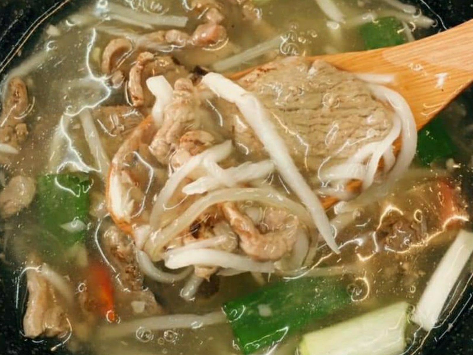 高雄大社廟口生炒鴨肉焿湯麵，木勺舀起鴨肉與豆芽菜特寫