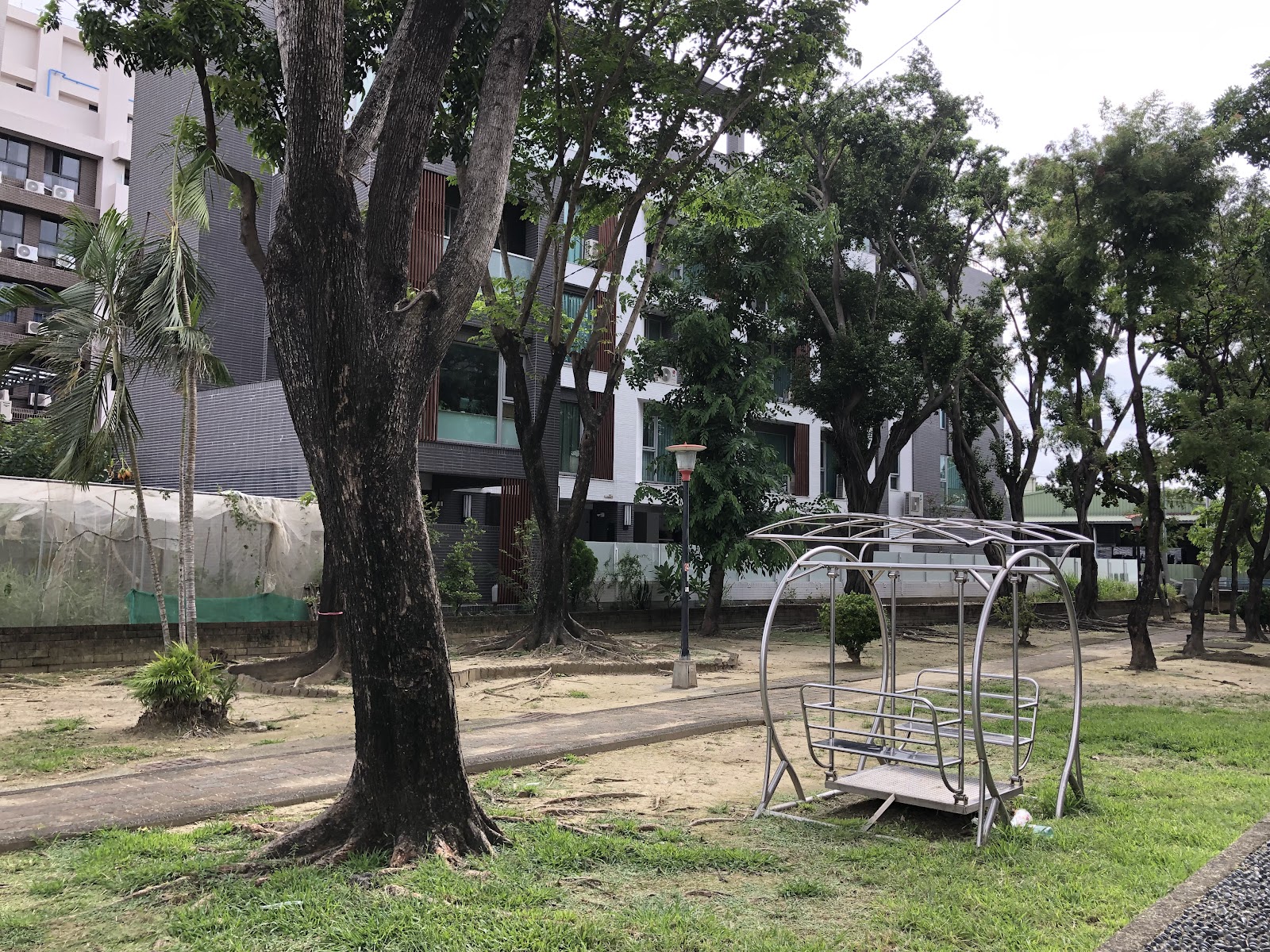 高雄大社三奶公園鞦韆遊具區，大樹與草地環繞