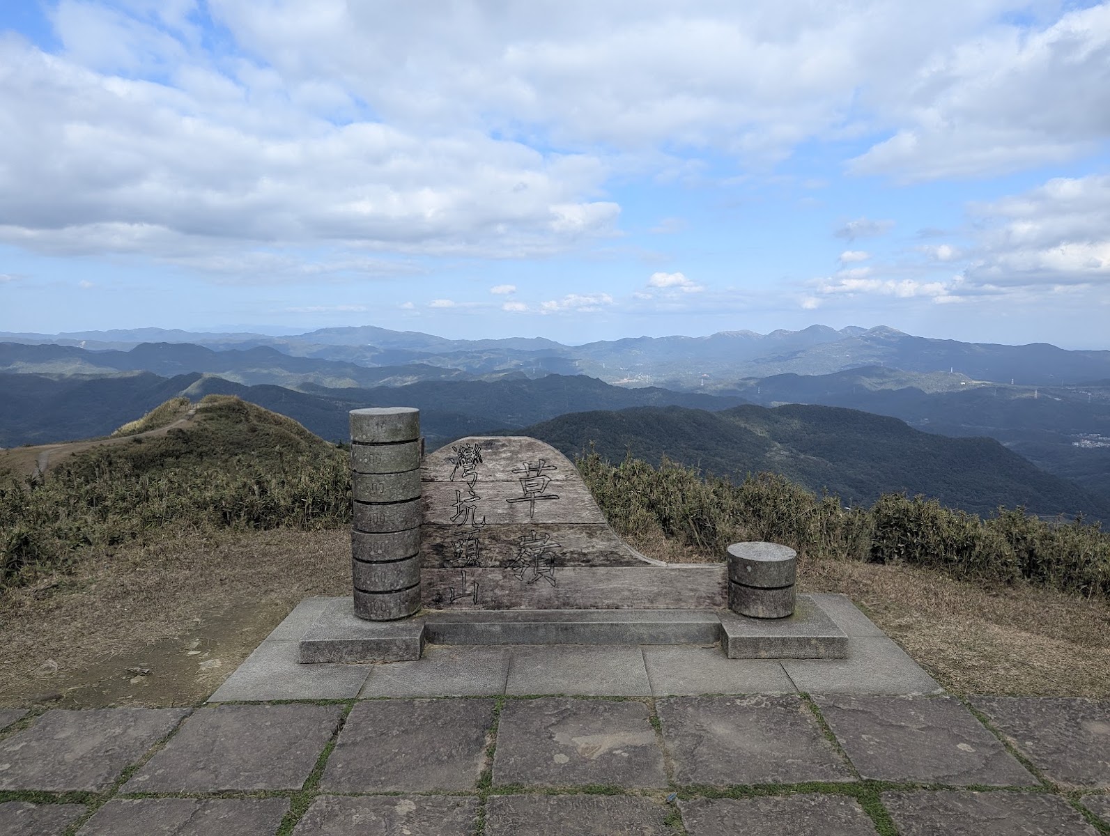 灣坑頭山山頂石砌觀景平台，木質雕刻座椅，群山雲霧環繞