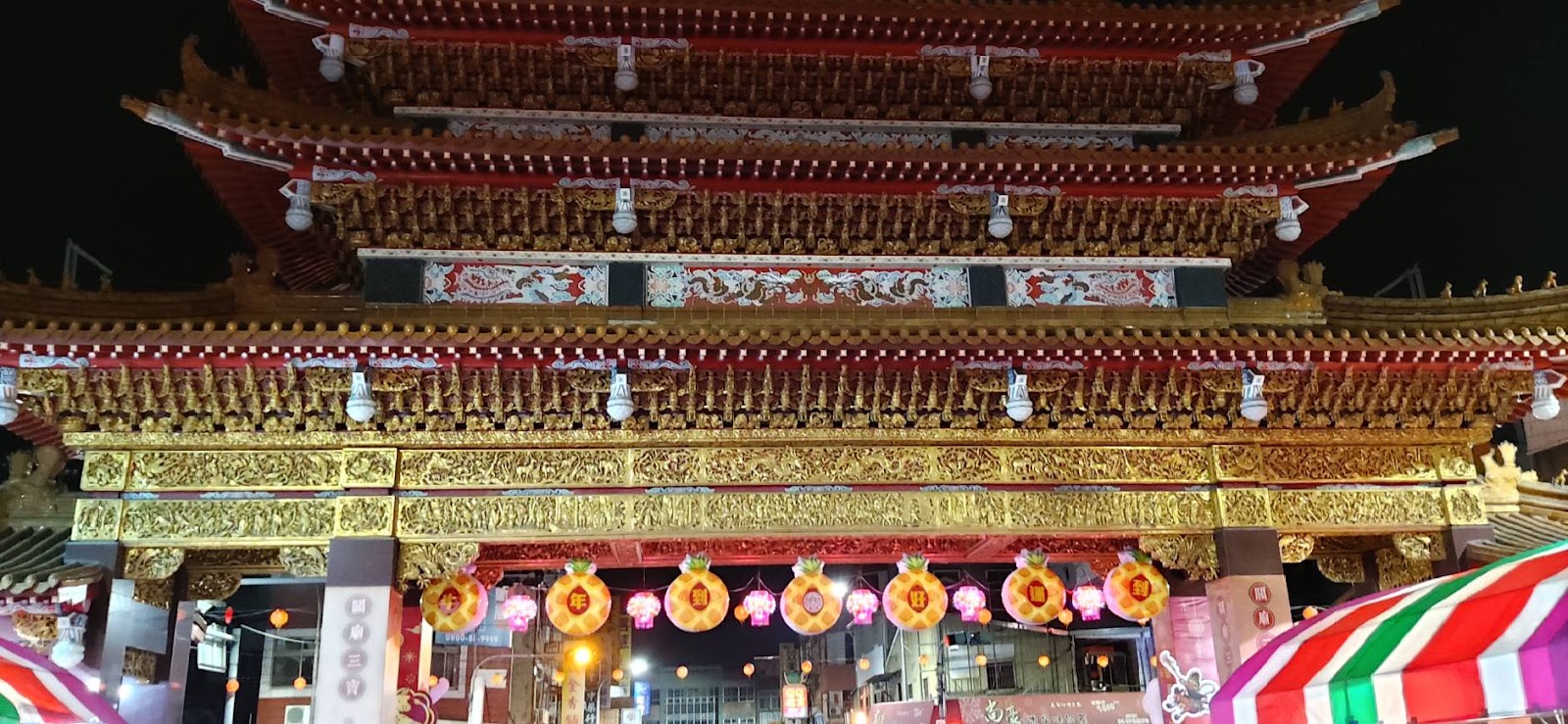 關廟山西宮夜間金色屋簷與鳳梨造型燈籠特寫