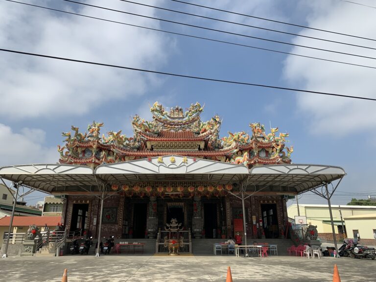 官田渡頭北極殿遠景正面，交趾陶剪黏屋脊，廟埕停放機車