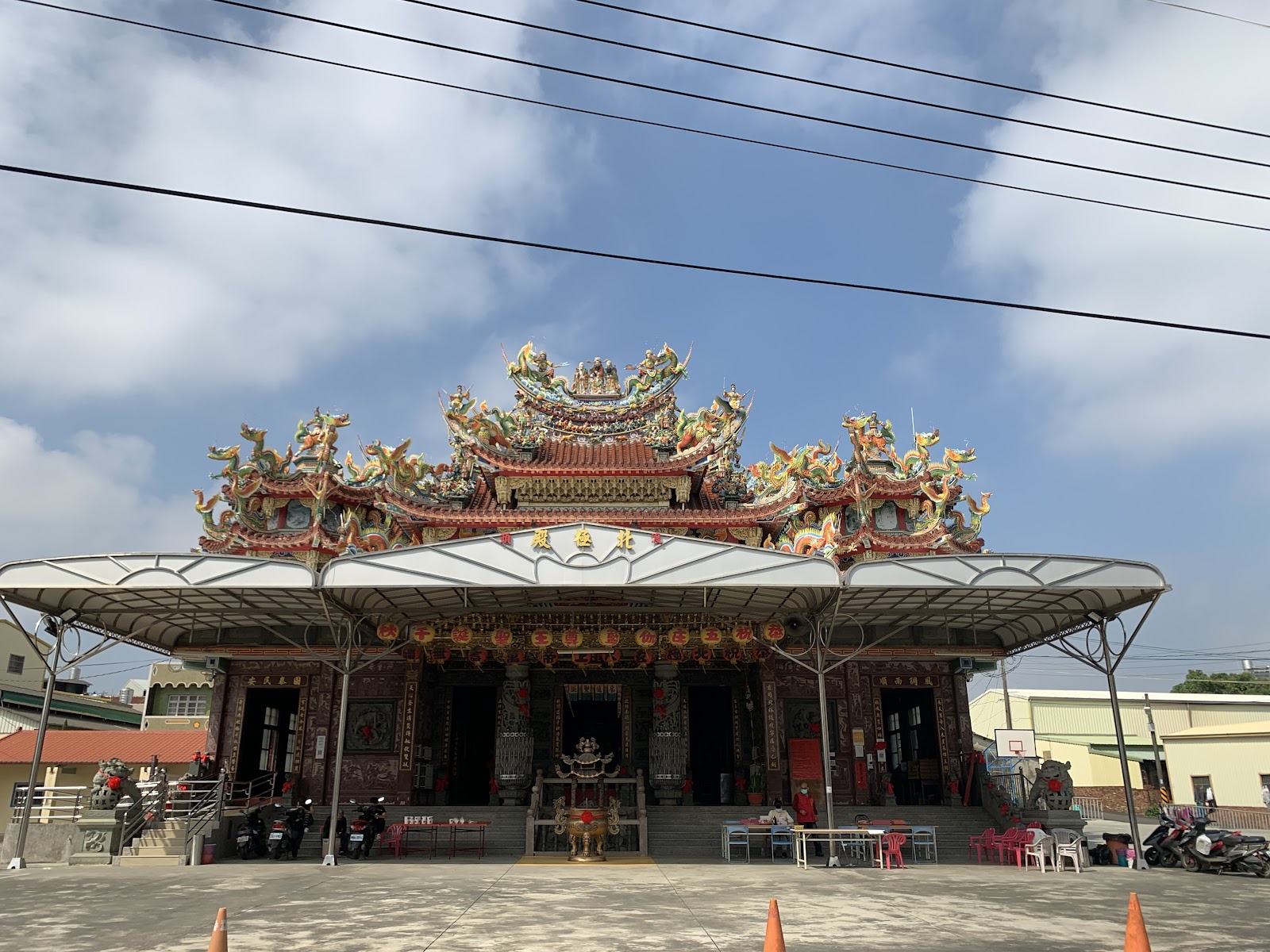 官田渡頭北極殿遠景正面，交趾陶剪黏屋脊，廟埕停放機車