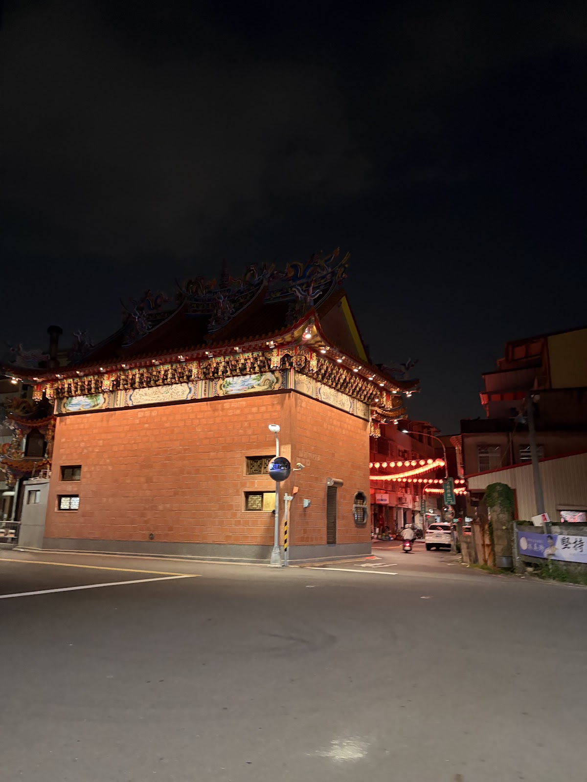 後勁福德祠夜間街角,紅磚廟牆與路口紅燈籠