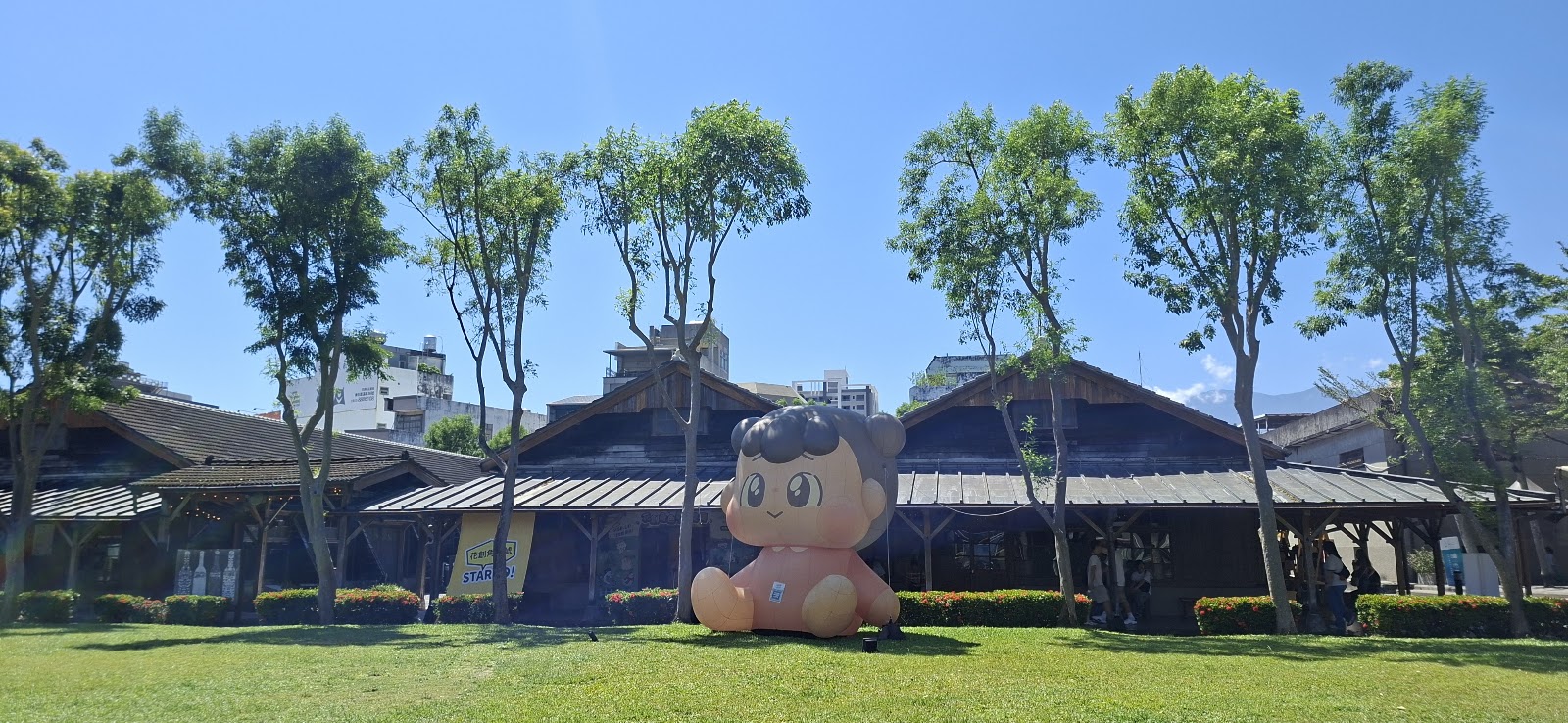 花蓮文創園區草坪上的巨大充氣公仔與老倉庫