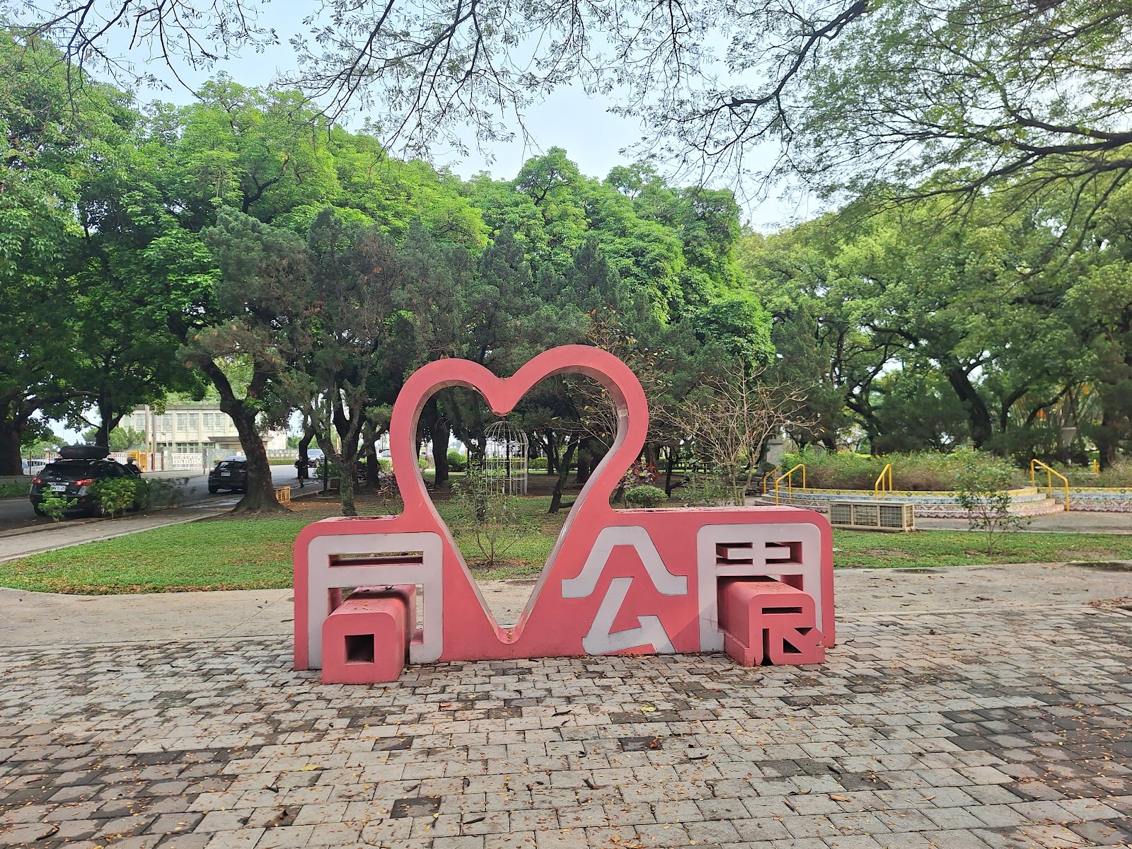同心公園－粉紅色「同心公園」愛心造型地標牌樓，背景綠意盎然