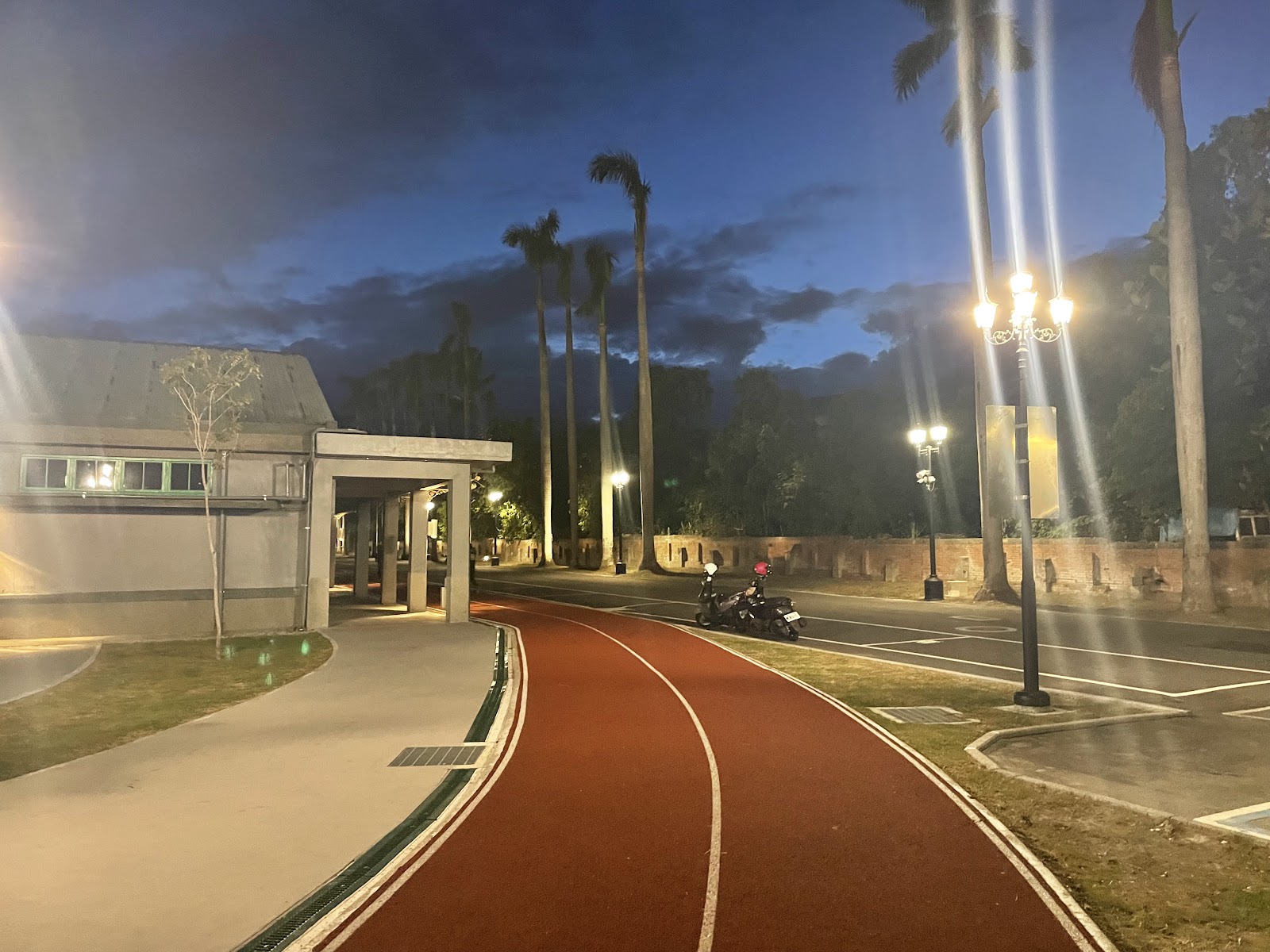 花蓮縣運動休閒園區黃昏磚紅色PU跑道與椰林大道