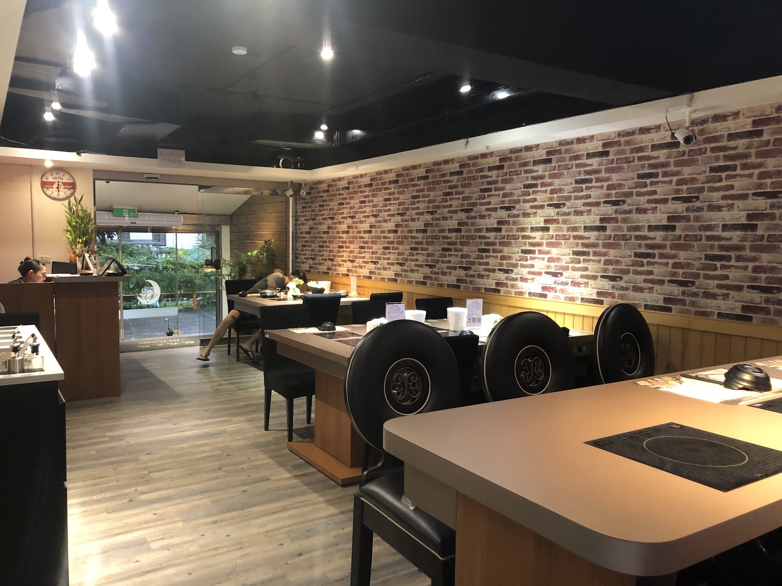 極喀食堂紅磚牆搭配黑色桌面卡座用餐區