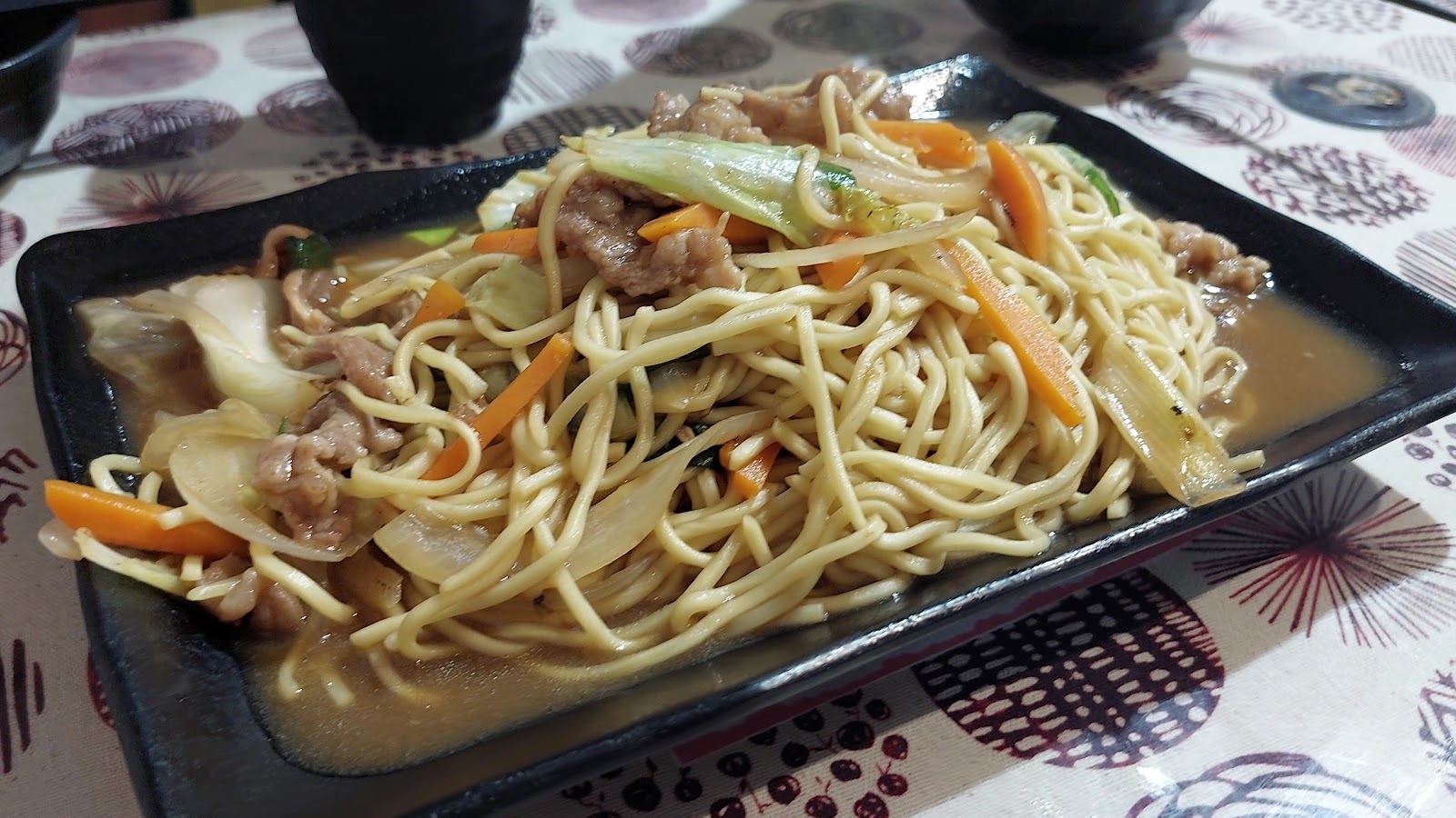 極喀食堂黑盤裝盛的日式炒麵料理