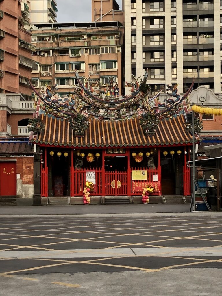景美集應廟正殿紅色廟門與燕尾翹脊，文山區百年老廟