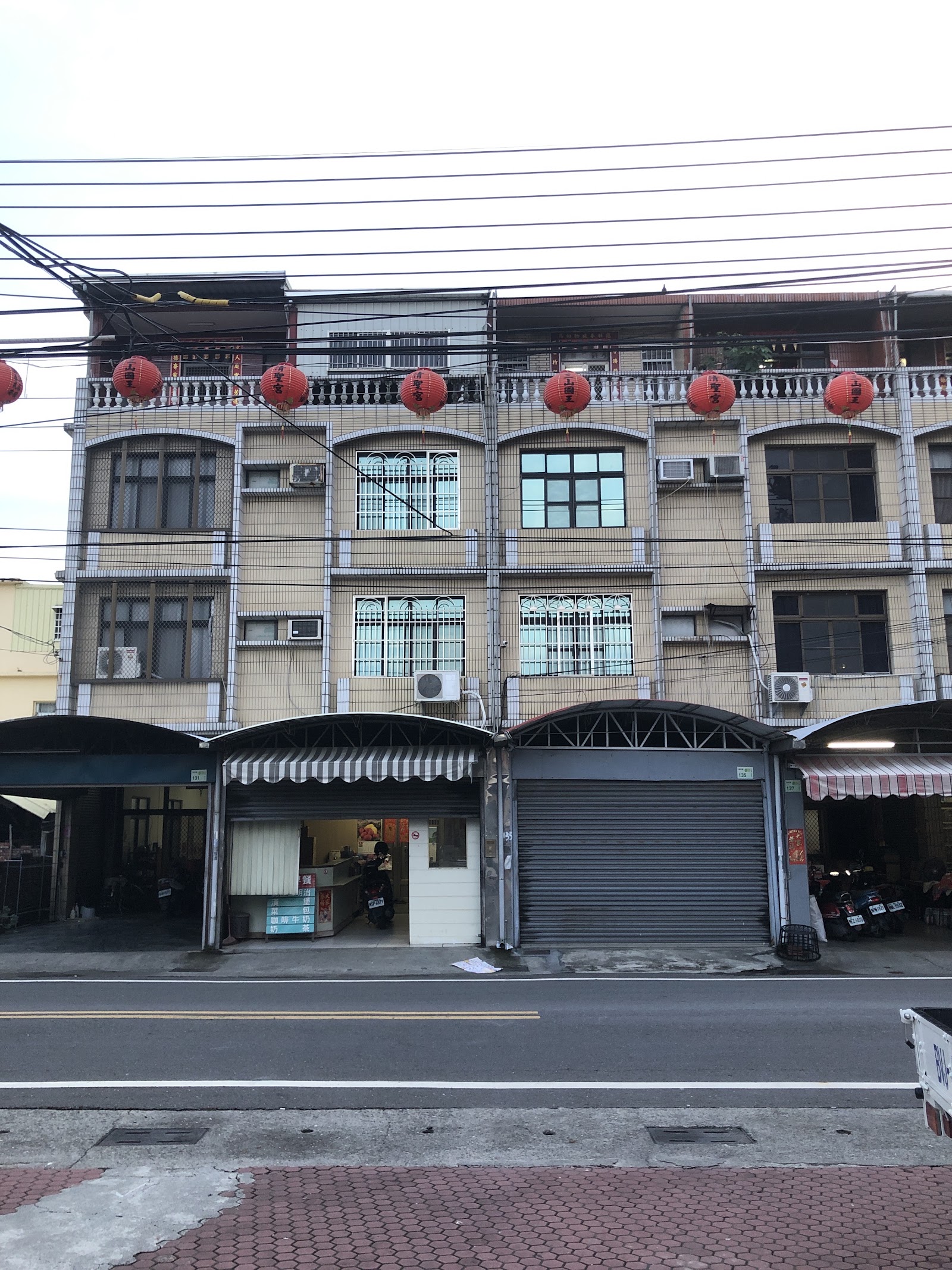 黃昏時分廟前紅燈籠串隨風搖曳,鄉間天色漸暗