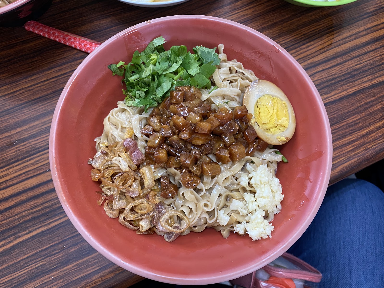 乾麵淋上滷肉燥,半熟滷蛋與香菜點綴,油蔥酥香氣撲鼻