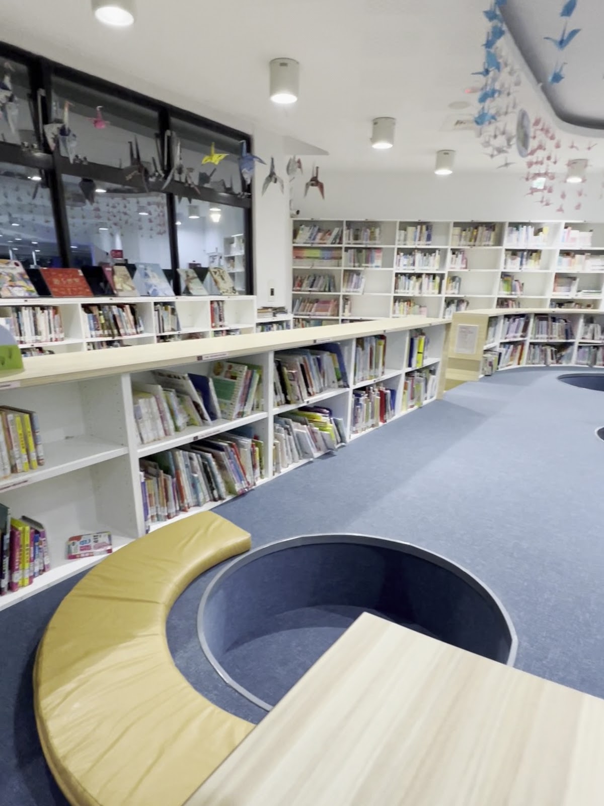 圖書館中正分館兒童區，鵝黃色弧形沙發與繪本書架