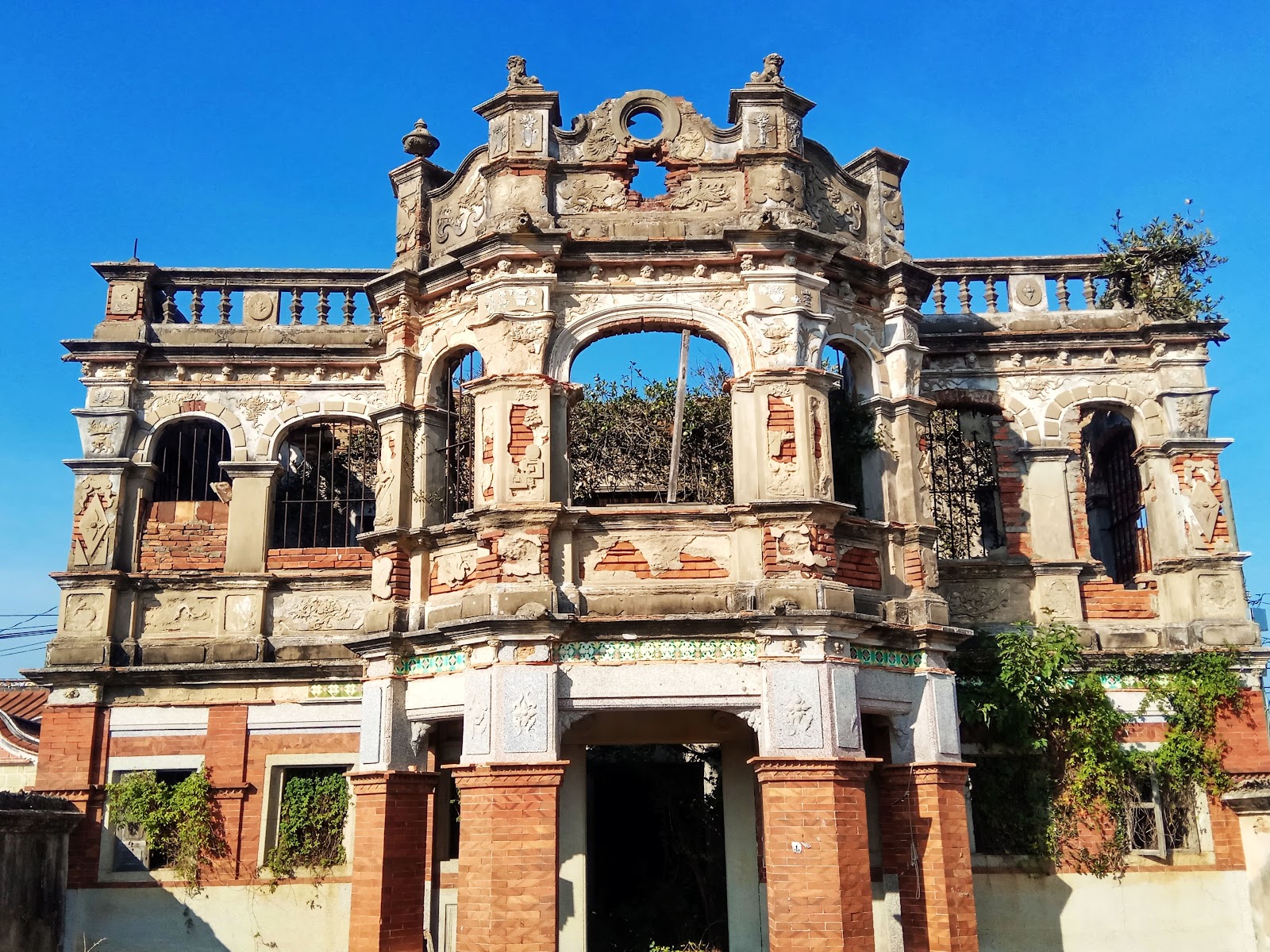 陳德幸洋樓正立面，精緻泥塑山頭浮雕，殘破卻氣派的洋樓建築