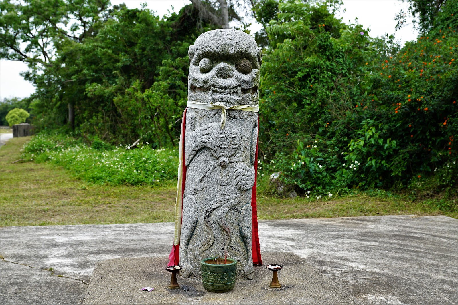 碧山風獅爺石雕，披著紅黃綵帶，前方擺放香爐