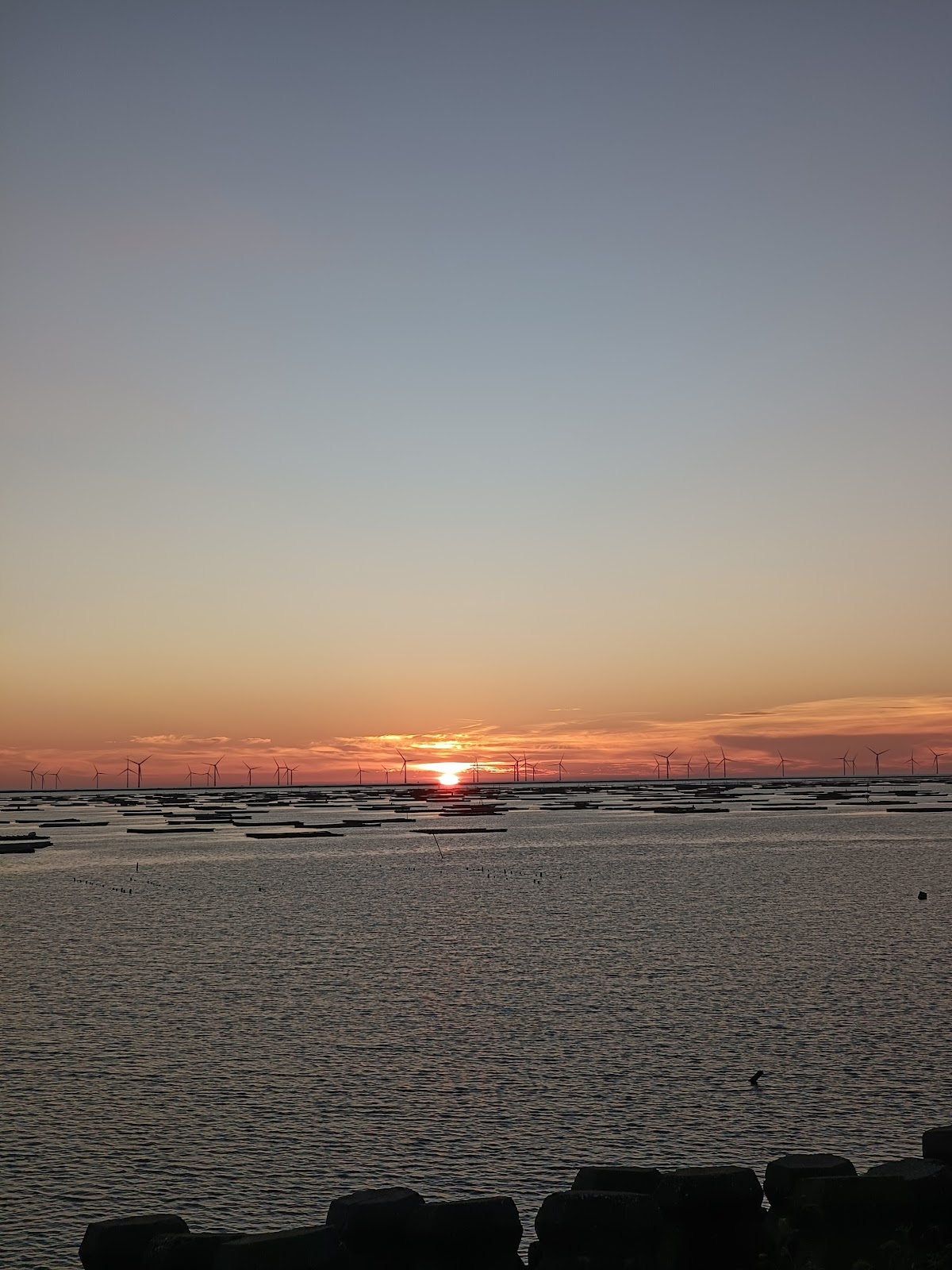 口湖臨海園-消波塊前景、夕陽緩緩沉入蚵棚與離岸風機之
