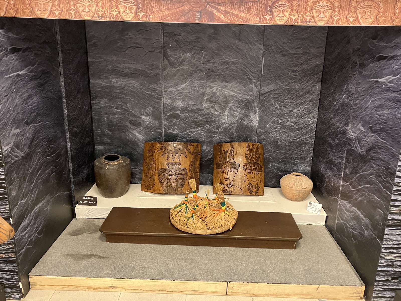 文物館展示櫃中的陶壺與木雕排灣族人像