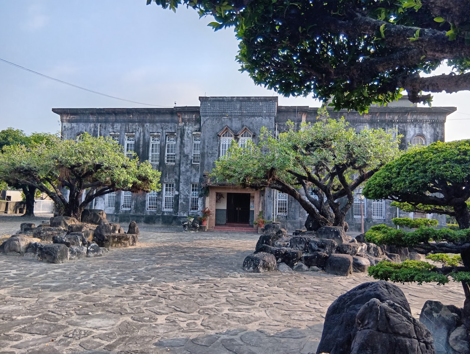 阮家古洋樓巴洛克風格正立面全景,拱窗列柱與枯山水造景