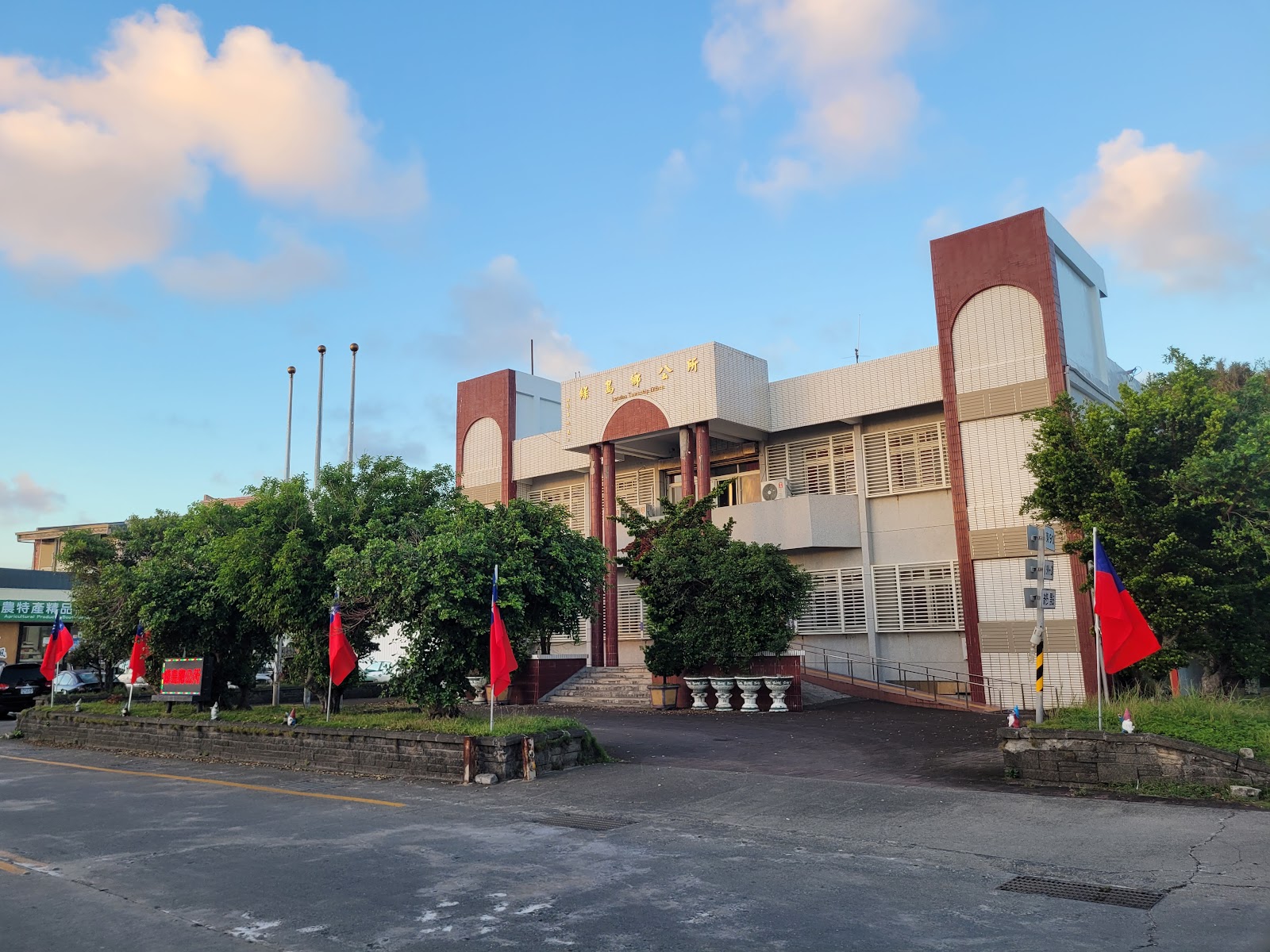 綠島鄉公所建築正面,傍晚藍天白雲與多支國旗飄揚