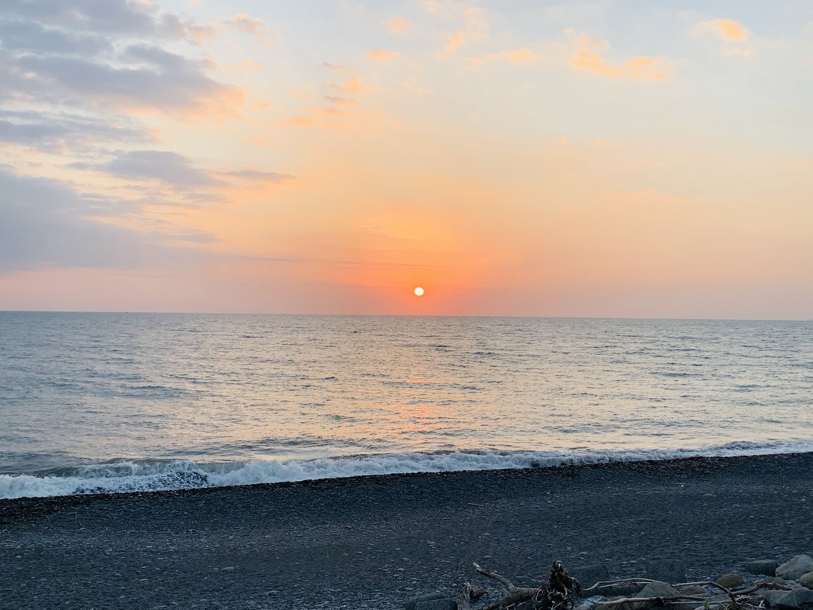加祿堂沙灘夕陽西下,橘紅天空倒映平靜海面