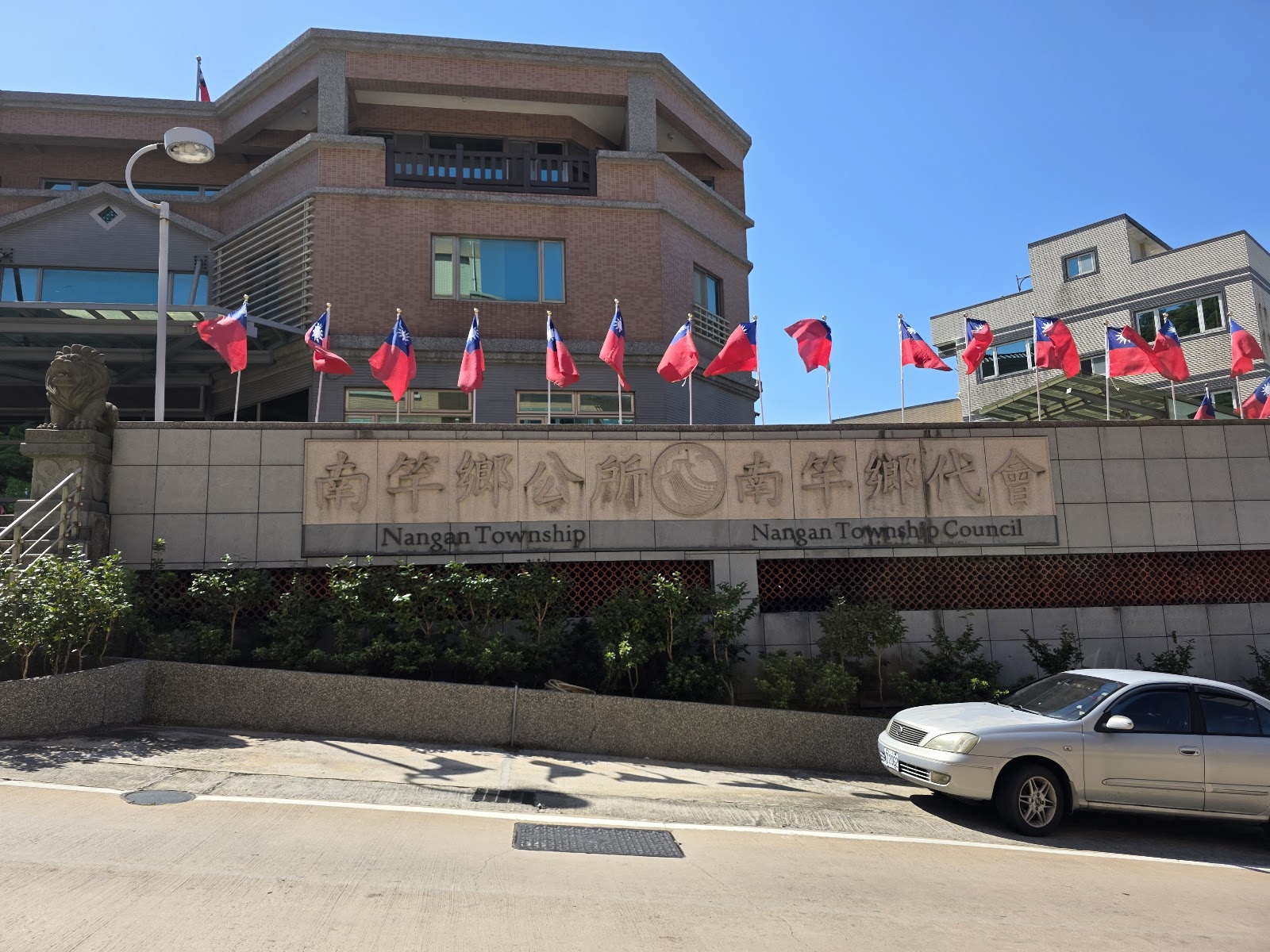 連江縣南竿鄉公所建築外觀，插滿國旗，藍天白雲
