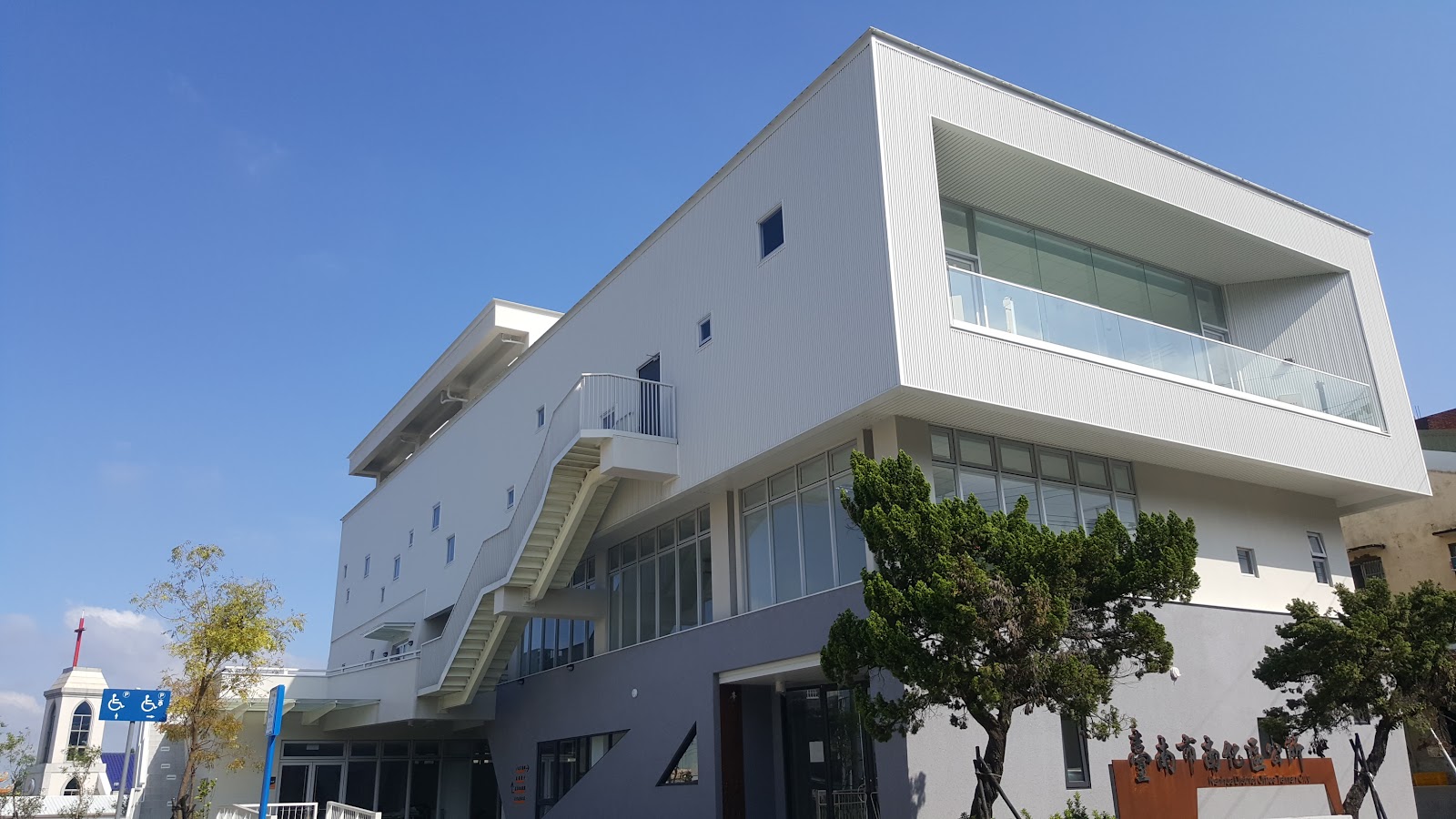白色現代建築外觀，南化區公所無障礙坡道與招牌清晰可見
