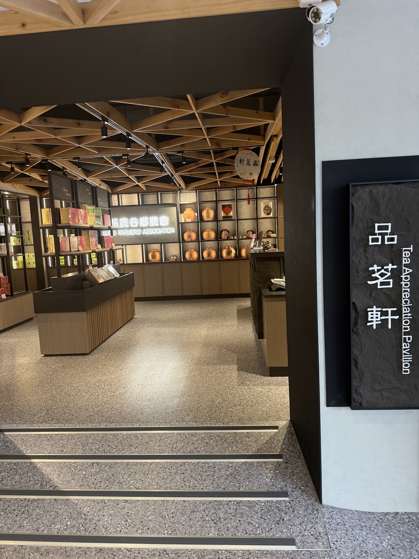 凍頂茶葉生產合作社品茗軒室內展售空間,木質格柵天花板與茶具展示櫃