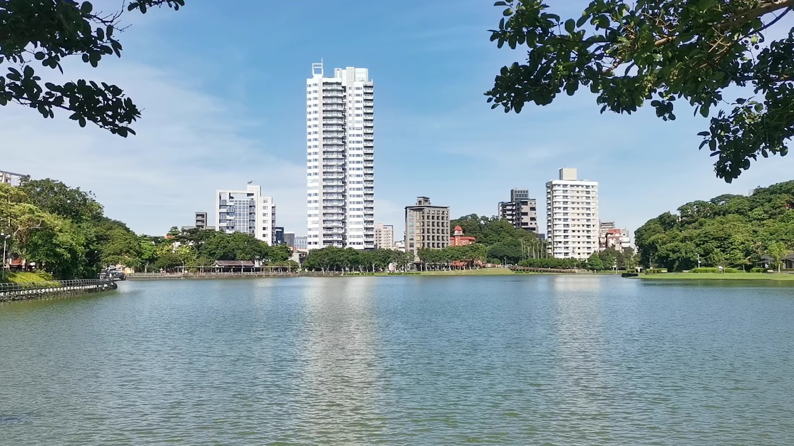 碧湖湖面倒映著岸邊高樓與藍天,環湖步道沿岸而行