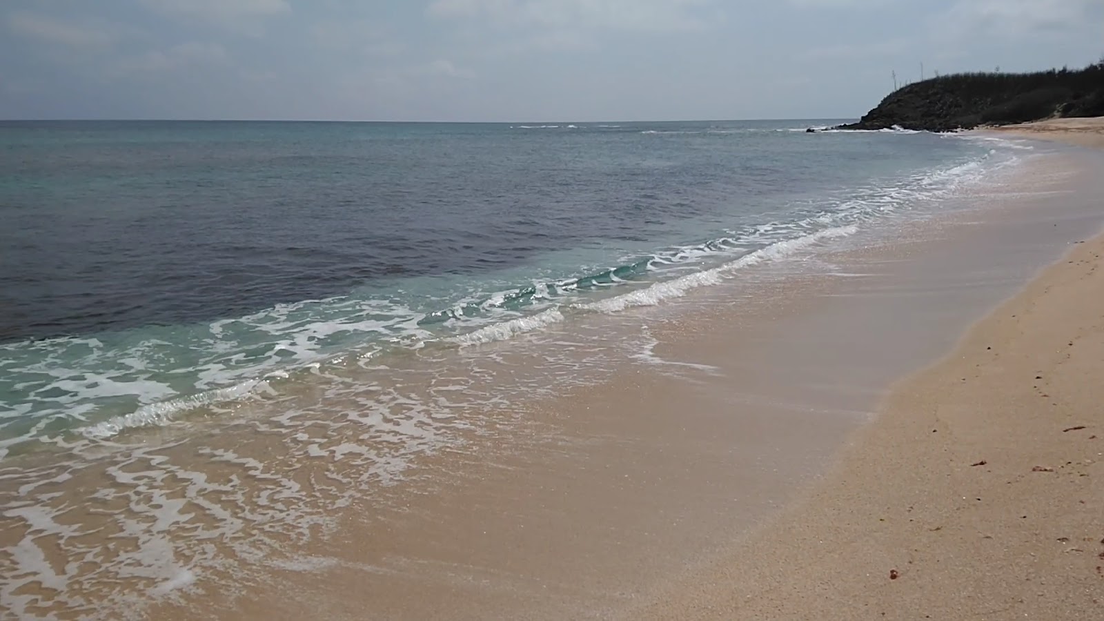裡正角沙灘清澈海水與浪花拍打沙岸