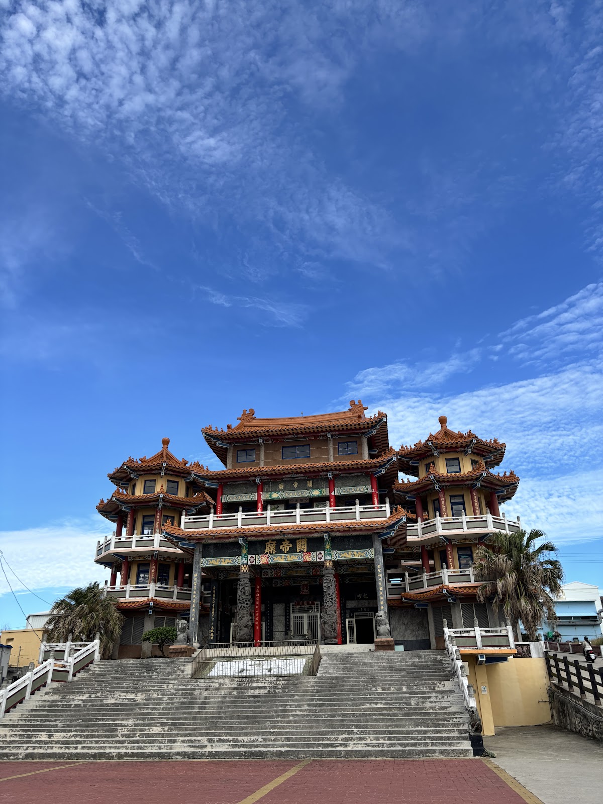 小池角關帝廟正面全景,藍天白雲下的三層宮殿式建築