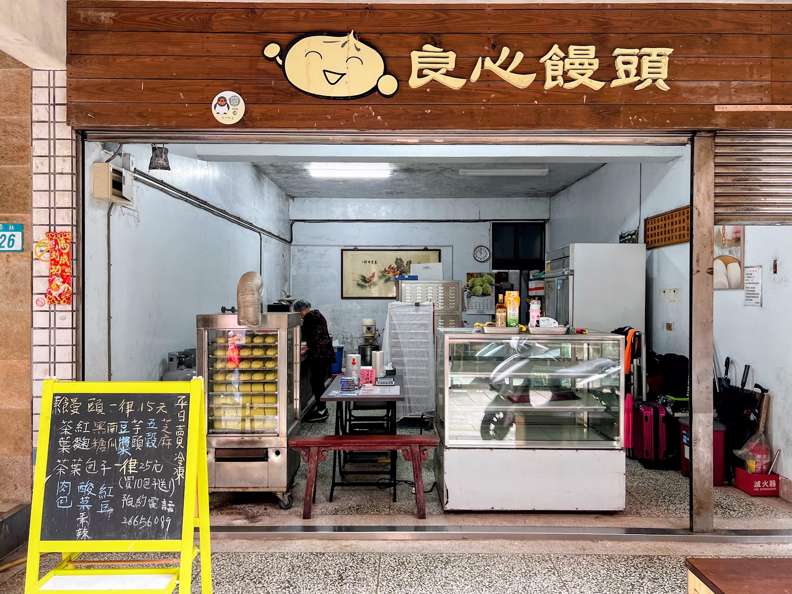 良心饅頭店面招牌與蒸籠,老闆正忙著蒸製饅頭