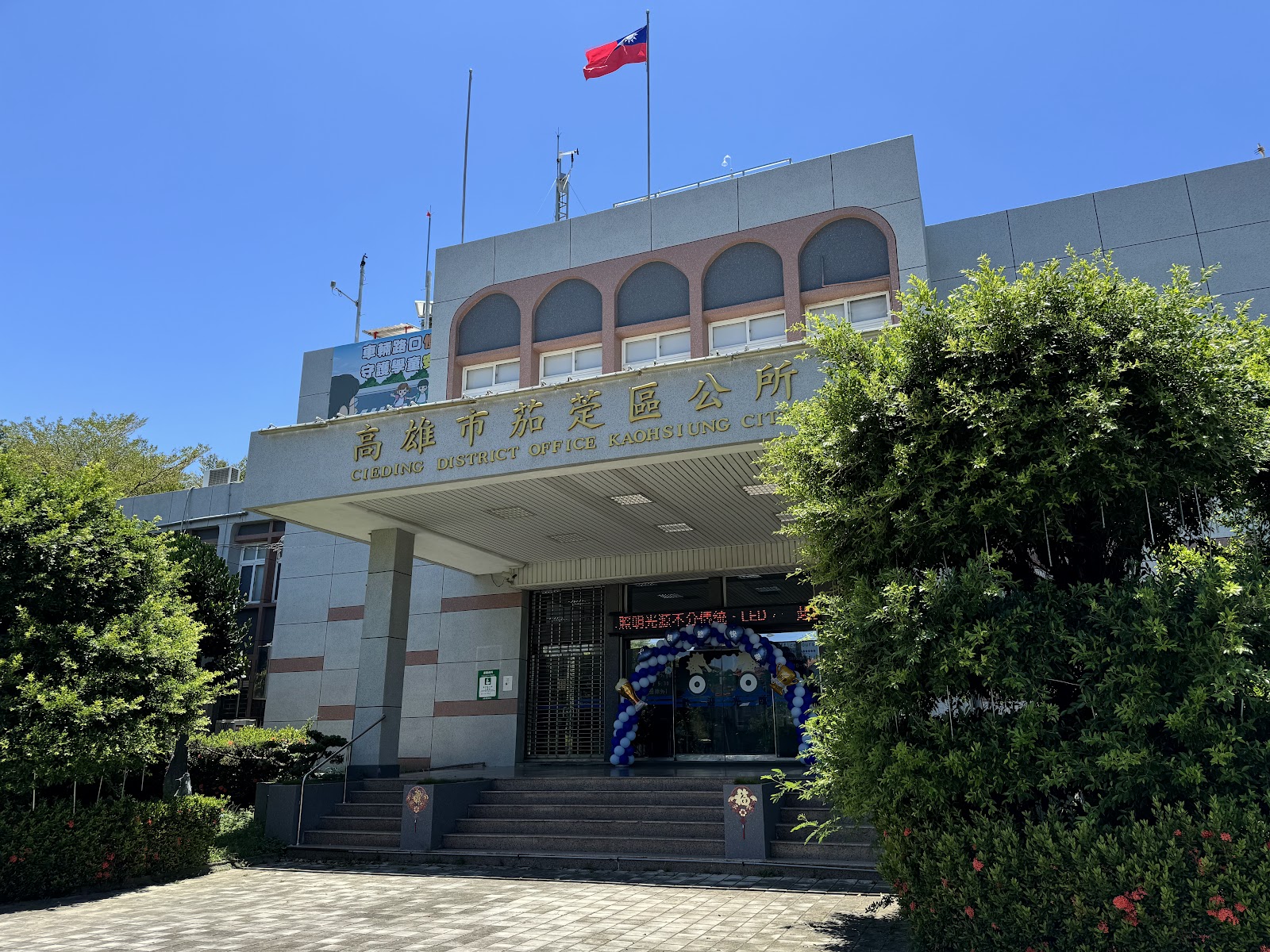 高雄市茄萣區公所外觀，白色建築與國旗