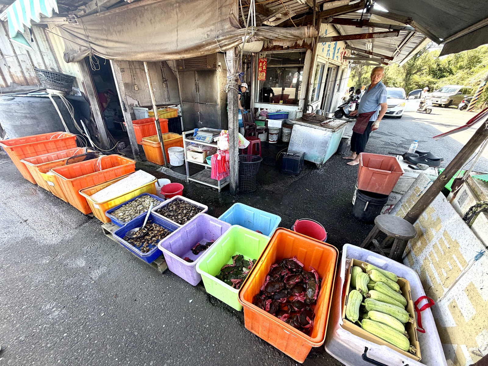 三股海鮮一條街三股海鮮一條街攤前成排膠箱盛裝現撈螃蟹、蚵仔與時令蔬果