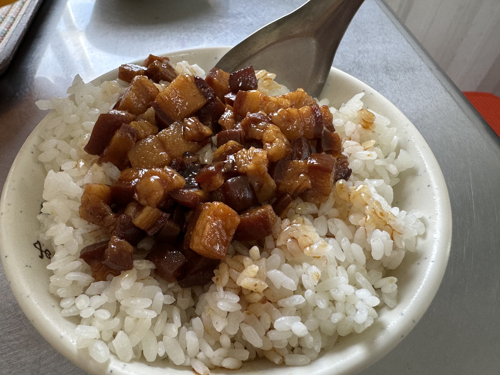 阿月虱目魚粥阿月虱目魚粥招牌焢肉飯特寫,醬燒方塊焢肉油亮噴香